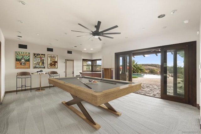 game room featuring a healthy amount of sunlight, a water view, and light carpet