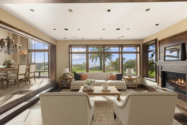 living room featuring a healthy amount of sunlight, light hardwood / wood-style floors, and an inviting chandelier