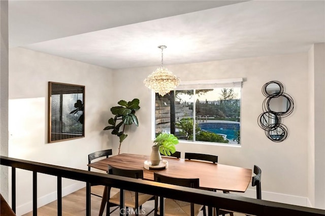 dining space with wood-type flooring and a notable chandelier