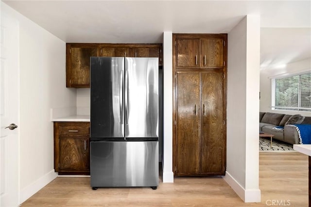 7385 Darnoch Way, West Hills, CA 91307 - kitchen with freestanding refrigerator, light wood-style flooring, dark brown cabinetry, and light countertops