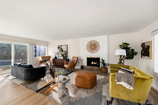 living room with hardwood / wood-style floors and a brick fireplace