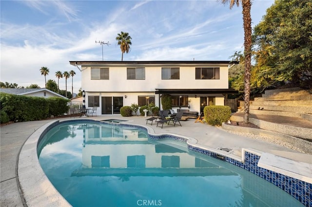 rear view of property with a patio and an outdoor hangout area