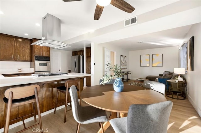 dining room with light hardwood / wood-style flooring and ceiling fan