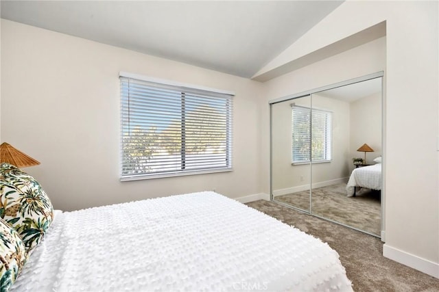 carpeted bedroom with a closet, lofted ceiling, and multiple windows