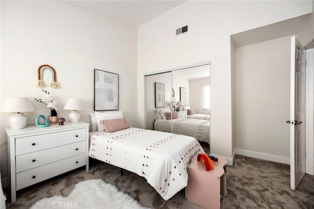 bedroom featuring dark carpet and a closet