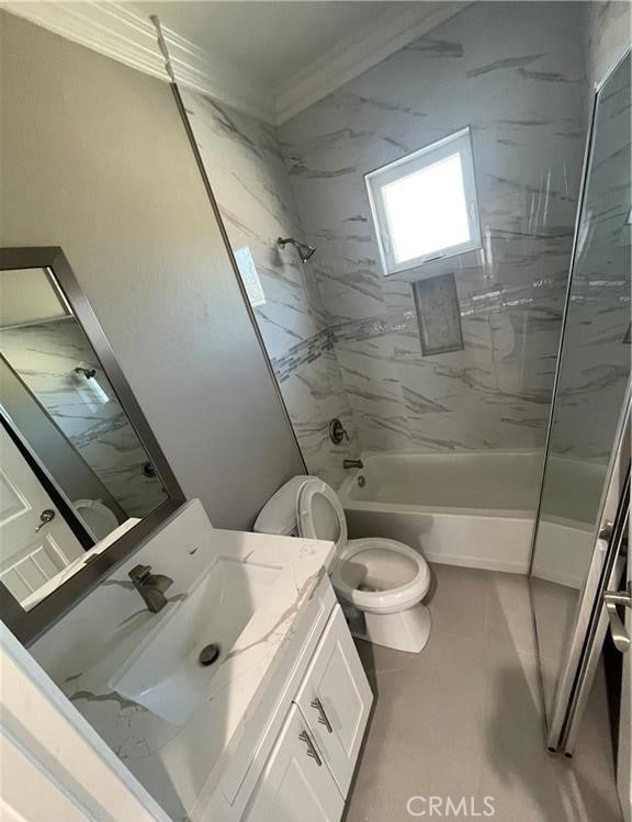 full bathroom featuring vanity, tiled shower / bath combo, ornamental molding, and toilet