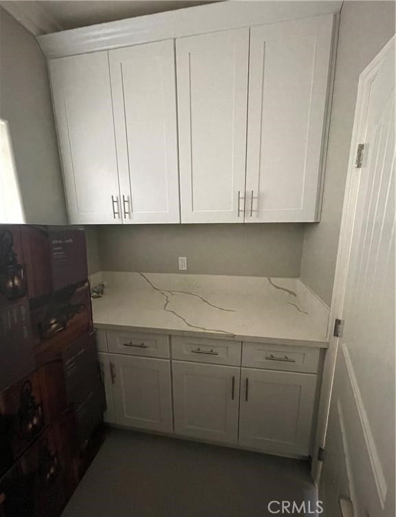 kitchen with light stone countertops and white cabinets