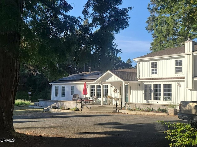 view of front facade featuring solar panels and a deck