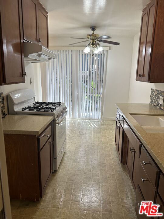 kitchen with gas range gas stove, sink, and ceiling fan