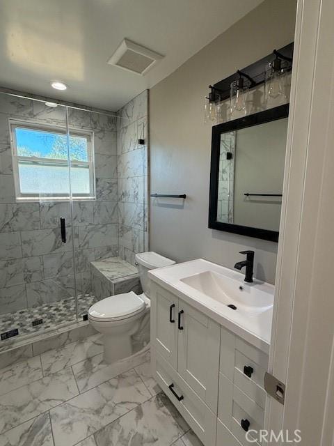 full bathroom with visible vents, vanity, marble finish floor, toilet, and a stall shower