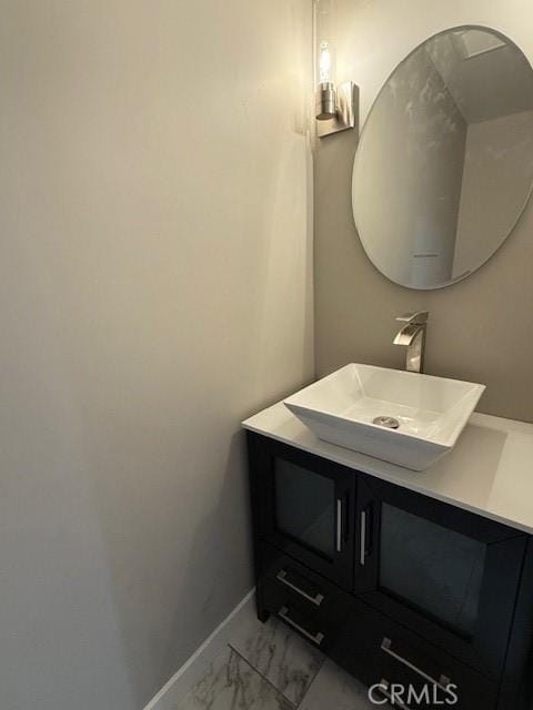 bathroom featuring marble finish floor, vanity, and baseboards