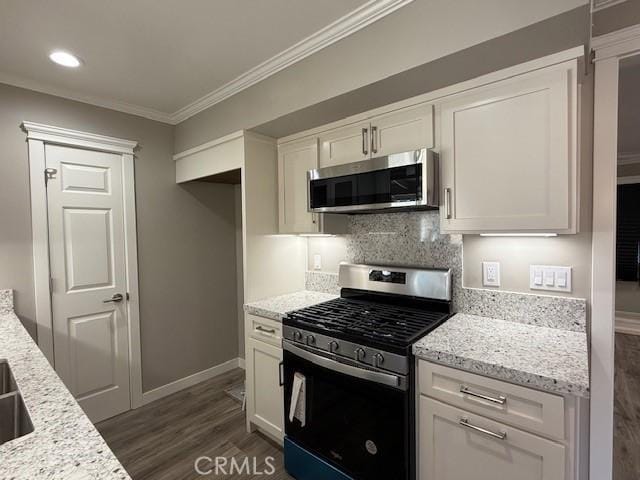 kitchen with crown molding, decorative backsplash, white cabinetry, dark wood finished floors, and stainless steel appliances