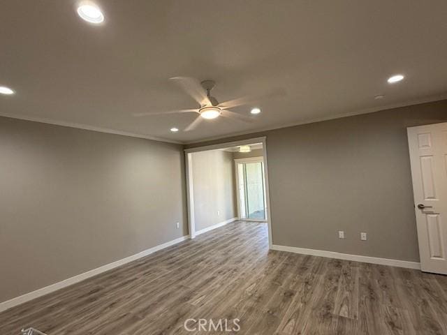 spare room featuring recessed lighting, baseboards, wood finished floors, and ornamental molding