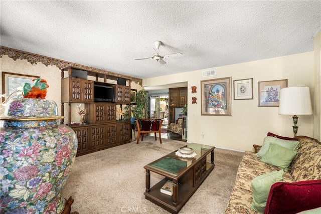 living room with carpet flooring, a textured ceiling, and ceiling fan