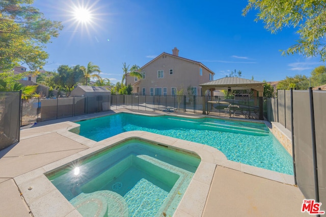 view of swimming pool featuring a gazebo, a patio area, and an in ground hot tub