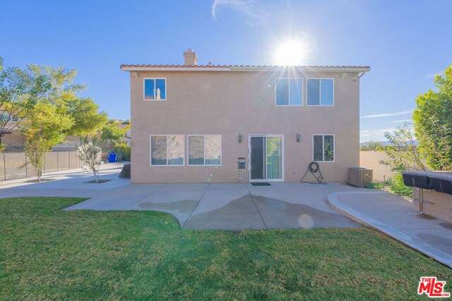 rear view of property featuring central AC unit, a lawn, and a patio