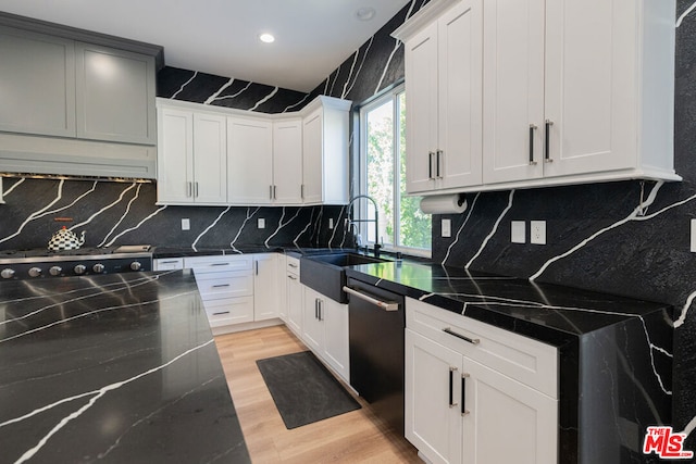 kitchen featuring sink, white cabinetry, dishwasher, and range hood