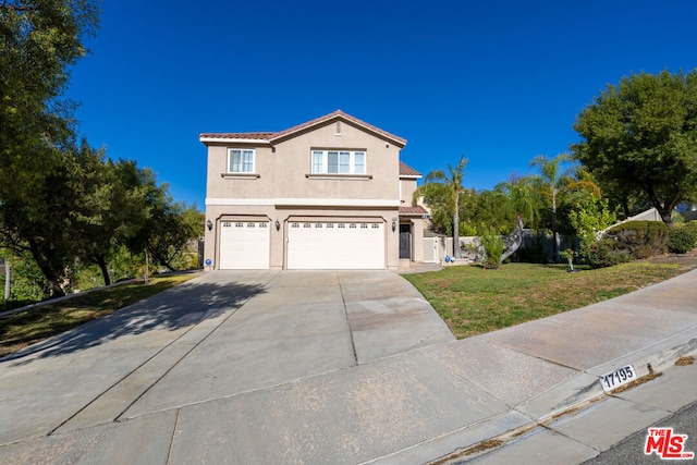 front facade featuring a front lawn and a garage