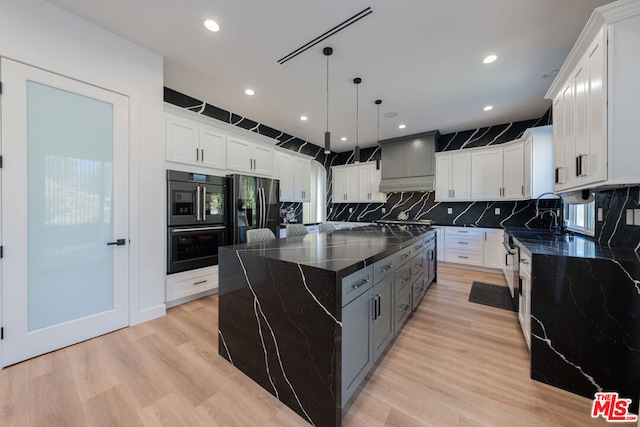 kitchen featuring pendant lighting, white cabinets, stainless steel fridge with ice dispenser, and a kitchen island