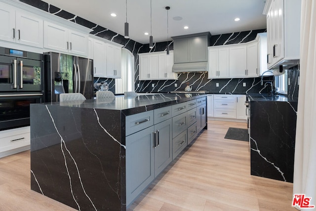 kitchen with gray cabinets, white cabinetry, hanging light fixtures, stainless steel fridge, and dark stone counters