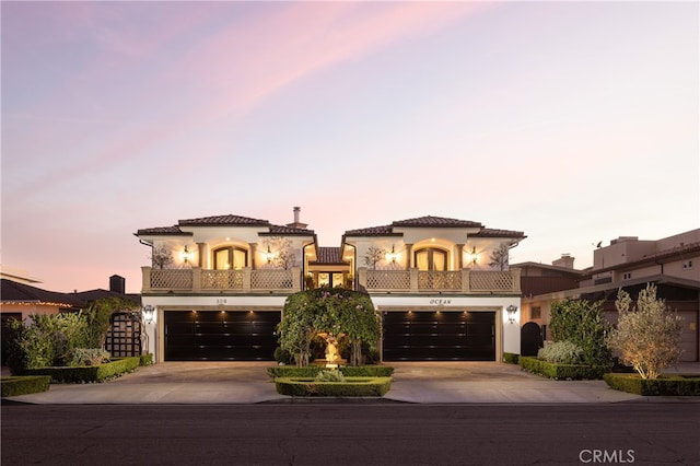 mediterranean / spanish-style house featuring a garage and a balcony