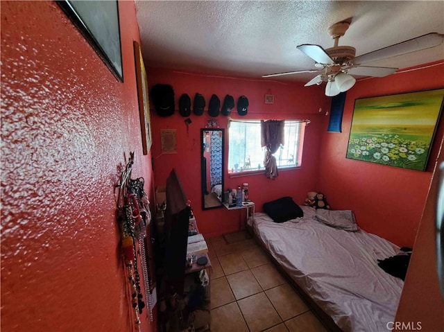 tiled bedroom with a textured ceiling and ceiling fan