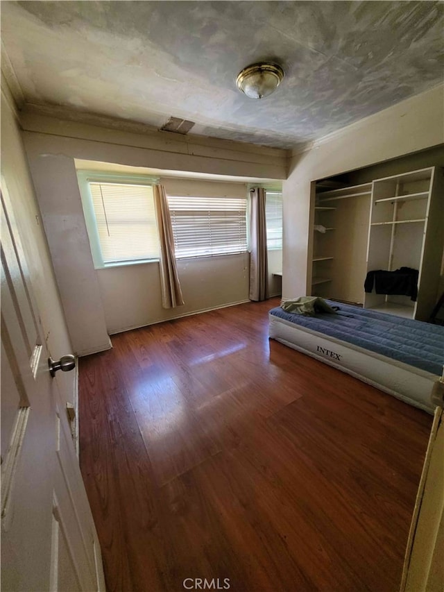 unfurnished bedroom with hardwood / wood-style floors and a closet