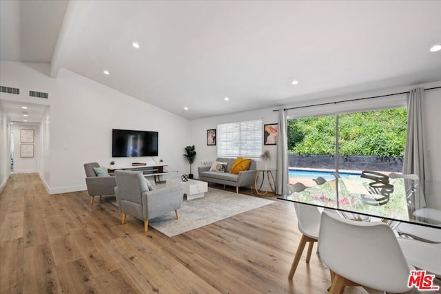 living room with lofted ceiling with beams and light wood-type flooring