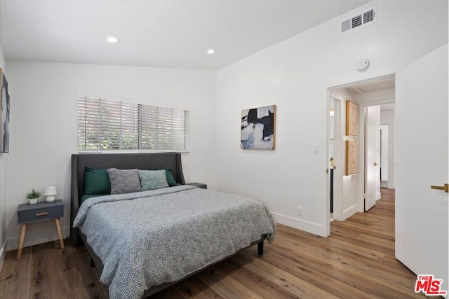 bedroom with lofted ceiling and hardwood / wood-style flooring