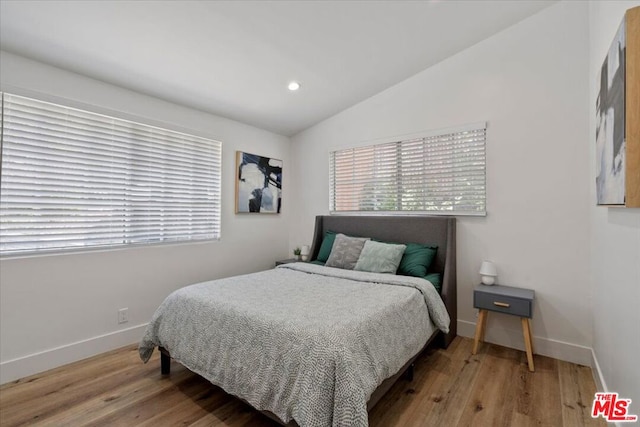 bedroom with wood-type flooring and lofted ceiling