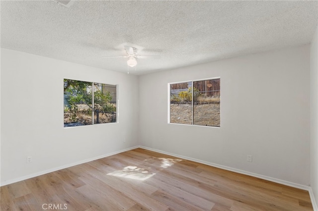 unfurnished room featuring a textured ceiling, light hardwood / wood-style floors, and plenty of natural light