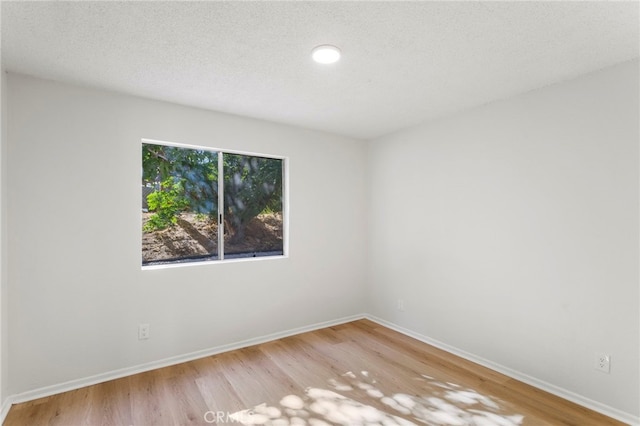 empty room featuring hardwood / wood-style flooring and a textured ceiling