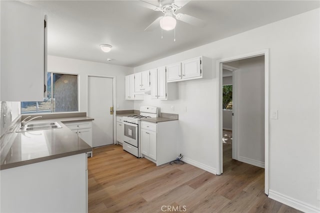 kitchen featuring white range, extractor fan, sink, light hardwood / wood-style flooring, and white cabinetry