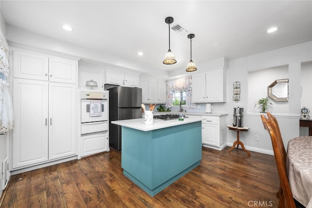 16132 Landmark Dr, Whittier, CA 90604 - kitchen with appliances with stainless steel finishes, a center island, white cabinetry, and dark wood-type flooring