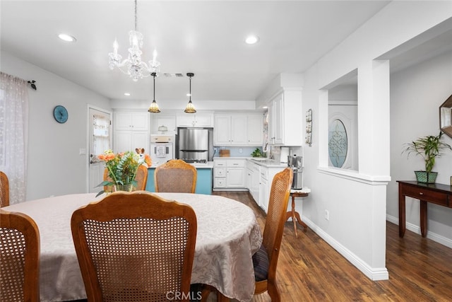 16132 Landmark Dr, Whittier, CA 90604 - dining area featuring dark hardwood / wood-style flooring, an inviting chandelier, and sink