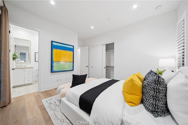 bedroom featuring connected bathroom, light hardwood / wood-style floors, and a closet