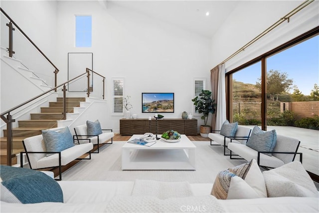 living room with high vaulted ceiling and light hardwood / wood-style floors