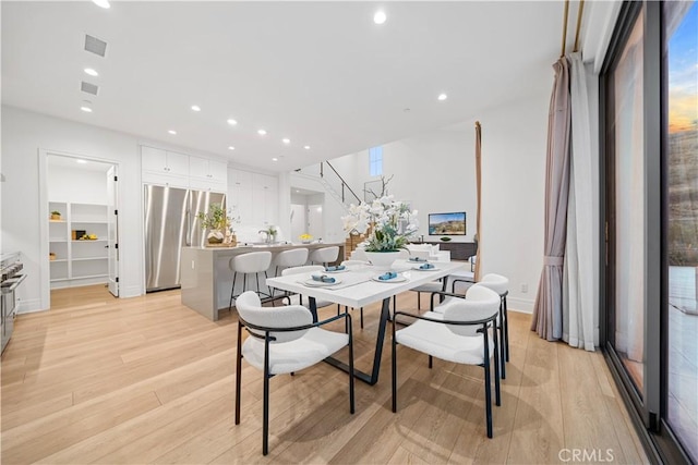 dining space with light hardwood / wood-style floors and a wealth of natural light