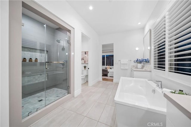 full bathroom with plus walk in shower, vanity, tile patterned floors, and toilet