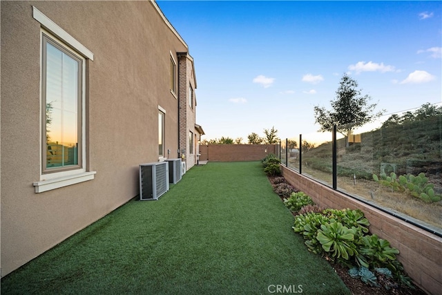 yard at dusk featuring cooling unit