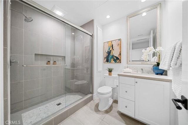 bathroom with tile patterned flooring, vanity, toilet, and walk in shower