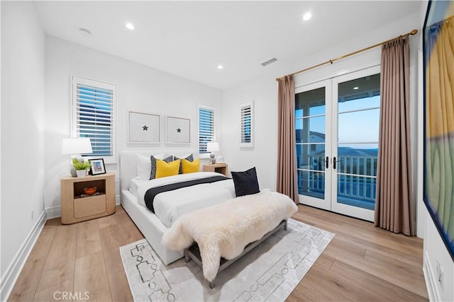 bedroom featuring french doors, light wood-type flooring, and access to outside