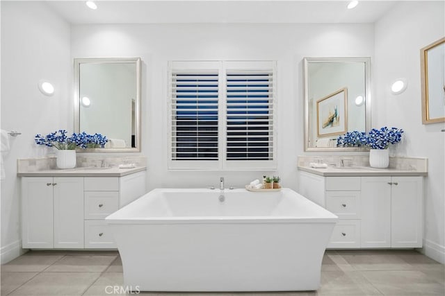 bathroom with tile patterned floors, a bathtub, and vanity