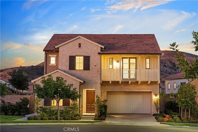 view of front of property featuring a mountain view, a garage, and a balcony