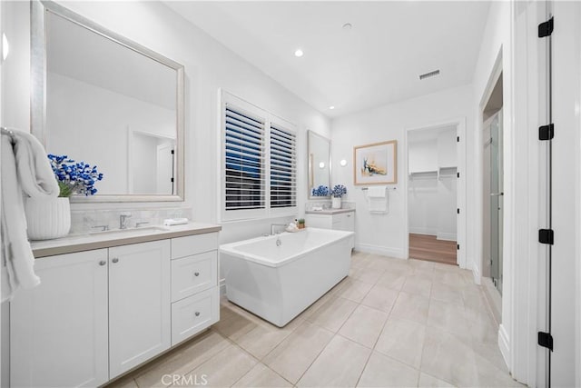 bathroom featuring tile patterned flooring, vanity, and a bathtub