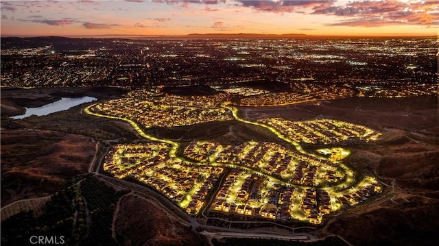 aerial view at dusk featuring a water view