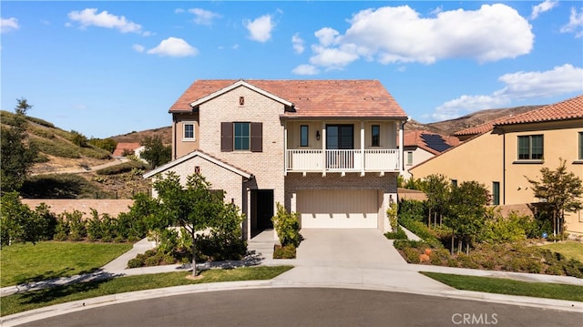 view of front of property with a mountain view, a garage, and a balcony