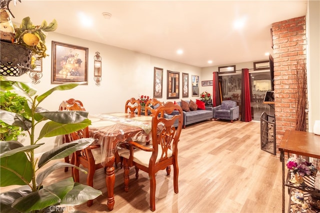 dining area with light hardwood / wood-style floors and a fireplace