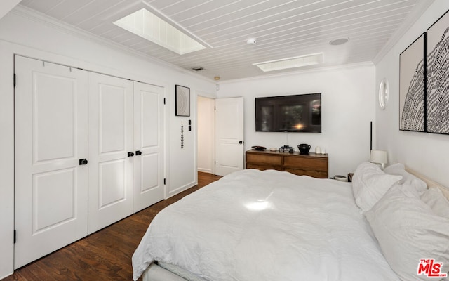 bedroom with dark hardwood / wood-style flooring, a closet, and ornamental molding