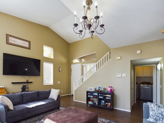 living room with washer / dryer, lofted ceiling, dark wood-type flooring, and an inviting chandelier